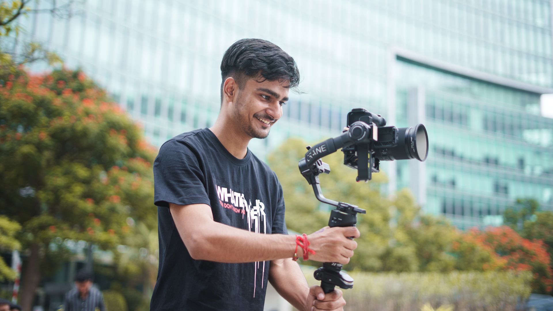 Criador de conteúdo filmando com gimbal em ambiente com vegetação e luz natural.